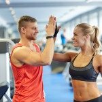 sport, fitness, lifestyle, gesture and people concept - smiling man and woman doing high five in gym